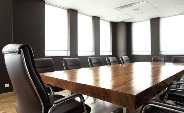Boardroom with leather chairs and wooden tabl